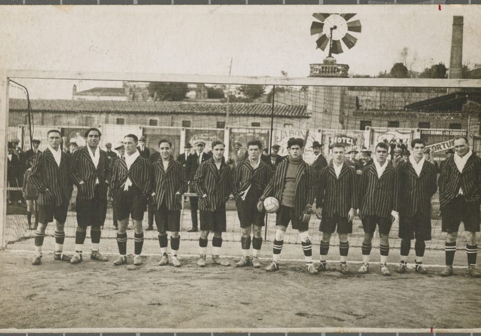 Retrat de grup de l'equip de futbol de la Unió Deportiva Girona amb uniforme davant d'una porteria del camp de futbol de Vista Alegre de Girona. S'identifica a Viñas, Poch, Weis, Santamaria, Feliu, Bosch, Gauchia, Colls, Carrera, Pons i Stamper.